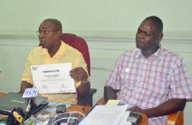 President of the GBA, Steve Ninvalle displaying Terrence Poole’s (in picture) certificate at Tuesday’s press briefing. Poole is at right. 