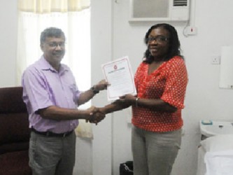 Photo shows Dr Kawal Dalip (left) receiving the certificate from GNBS’s Evadnie Ennis. 