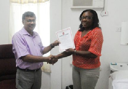 Photo shows Dr Kawal Dalip (left) receiving the certificate from GNBS’s Evadnie Ennis.

