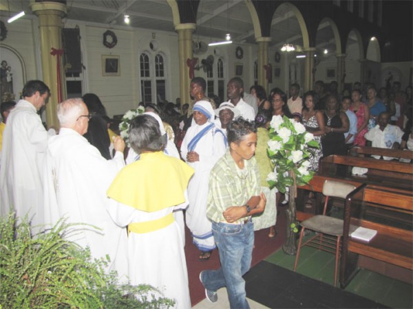 Preparing for 2014: Catholics during Mass at the Roman Catholic Church of the Ascension in New Amsterdam on Old Year’s Night. 