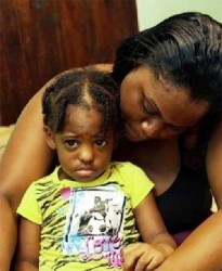 In safe arms: Andrea Leitch-Mohammed holds her daughter Kassie Providence at a house in south Trinidad where they are staying. (Newsday photo)