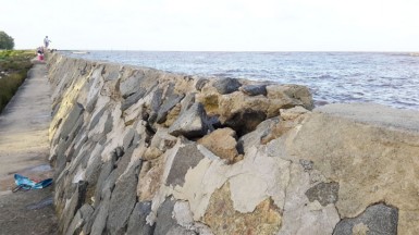 Boulders beginning to crumble at the top of the seawall. 