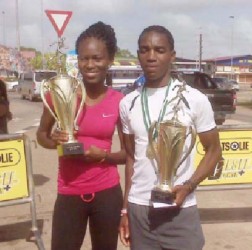 Alika Morgan and Kelvin( Johnson posing with their spoils after Sunday’s Bigi Broki Waka 10km road race which was staged Paramaribo, Suriname. 