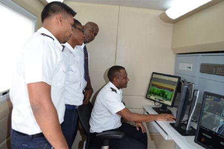 Guyana Revenue Authority (GRA) staffers monitoring scanner operation from the control room of the mobile scanner (GINA photo)