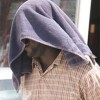 Sherlock Reid covered his face as he was escorted out of court on Monday.