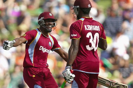 Century makers Dwayne Bravo, left and Kirk Edwards celebrate on the way to their team’s whopping 2-3-run win over New Zealand yesterday in the fifth and final One Day International which ensured the West Indies a share of the series. (Cricket365 photo)