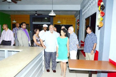 Proprietress Sheron Persaud (foreground) leading President Donald Ramotar on a tour of the hotel (GINA photo)