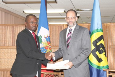 Haiti’s first ambassador to Caricom Peterson Noel (left) presenting his letters of credence to Caricom Secretary-General Irwin LaRocque (Arian Browne photo)