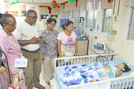 From right: Cybil Edwin looking at her 4-year-old daughter, Reanna Edwin with RNCF’s Doris Lewis and Michael Gordon and a hospital official.