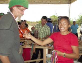 Jessica George (right), from the KMCRG Fair committee gives a medal to first time participant, Paul Correia, a well-known jewellery artisan in Lethem (KMCRG photo) 