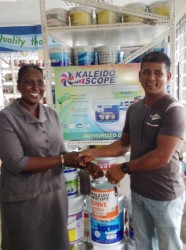 First place winner, Munilall Mohanlall (right), as he received his prize from a staff member of Toolsie Persaud. Mohanlall is one of a number of customers who won prizes following the drawing of the company’s Christmas promotion. 