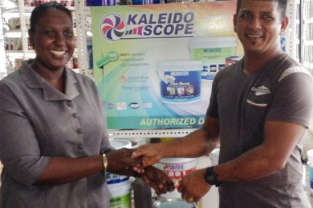 First place winner, Munilall Mohanlall (right), as he received his prize from a staff member of Toolsie Persaud. Mohanlall is one of a number of customers who won prizes following the drawing of the company’s Christmas promotion. 
