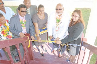 Chief Magistrate Priya Sewnarine-Beharry (right), Clerk of Court for the West Demerara Magisterial District Haimwantie Singh (third, right) and Attorney General Anil Nandlall (third, left) assist President Donald Ramotar (second, right) with the ceremonial cutting of the ribbon to declare the building open. Also in photo are Acting Chancellor of the Judiciary Justice Carl Singh (fourth, left) and regional officials. (Photo by Arian Browne)