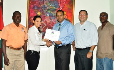 Alysa Xavier receives her Pan American Hockey Federation (PAHF) certificate from Minister of Culture, Youth and Sport, Dr. Frank Anthony (centre) while Guyana Hockey Board (GHB) President Philip Fernandes (second right), GHB Vice President Ivor Thompson (right) and Guyana Olympic Association (GOA) representative Deion Nurse look on. (Orlando Charles photo)    
