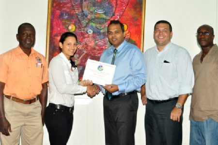 Alysa Xavier receives her Pan American Hockey Federation (PAHF) certificate from Minister of Culture, Youth and Sport, Dr. Frank Anthony (centre) while Guyana Hockey Board (GHB) President Philip Fernandes (second right), GHB Vice President Ivor Thompson (right) and Guyana Olympic Association (GOA) representative Deion Nurse look on. (Orlando Charles photo)
