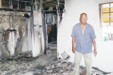 Shamlal Khodai stands in his damaged house