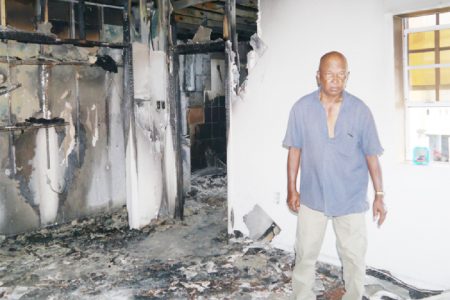 Shamlal Khodai stands in his damaged house