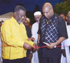 Prime Minister Samuel Hinds (left) and Minister in the Ministry of Finance Jun Edghill cutting the ribbon to officially open the arch. (GINA photo)  
