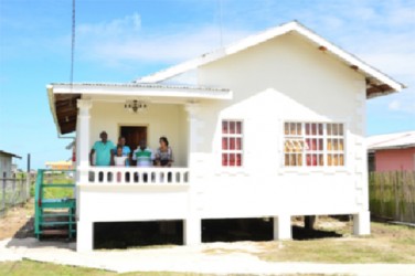 A family at their expanded core home (GINA photo) 