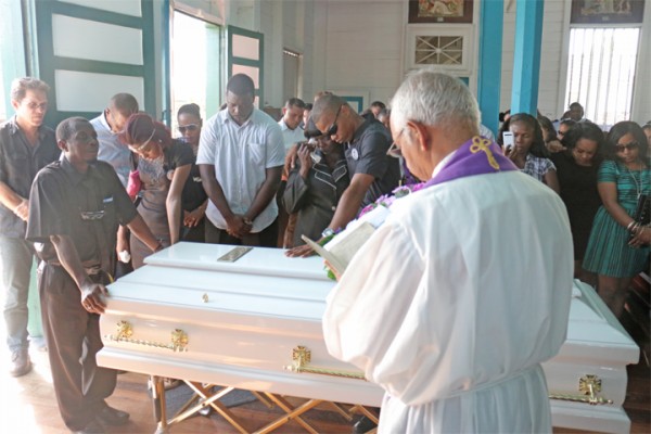 Saying goodbye: Family and friends paying their last respects to Trans Guyana Airways cargo handler Dwayne Jacobs-Newton yesterday at the St John the Baptist RC Church, Plaisance, East Coast Demerara. Jacobs-Newton died along with pilot Blake Slater when their plane crashed in the Middle Mazaruni jungle on January 18. (Photo by Arian Browne)