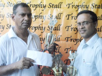 President of the Guyana Chess Federation Shiv Nandalall (right) receives a cheque from Trophy Stall owner Ramesh Sunich for sponsorship of the Trophy Stall chess tournament which begins today at 10am at the Carifesta Sports Complex. 