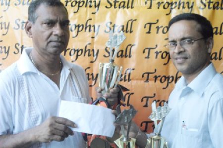 Managing Director of Trophy Stall Ramesh Sunich (left) hands over the sponosrhip for today’s repid chess tournament to president of the Guyana Chess Federation Shiv Nandalall.