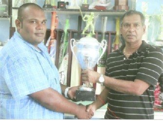 Trophy Stall proprietor Ramesh Sunich, right, hands over the trophies to Moonish Singh of the Rose Hall Youth and Sports Club. 