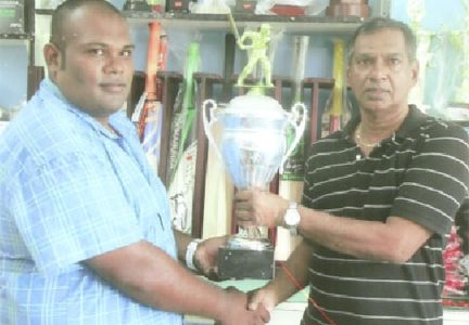 Trophy Stall proprietor Ramesh Sunich, right, hands over the trophies to Moonish Singh of the Rose Hall Youth and Sports Club.