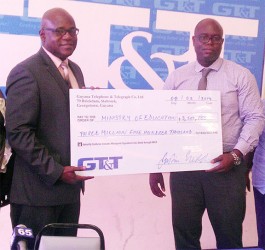 Chief Education Officer Olato Sam (left) receiving a cheque from GT&T Chief Financial Officer Justin Nedd for the Children’s Costume Parade 2014.  