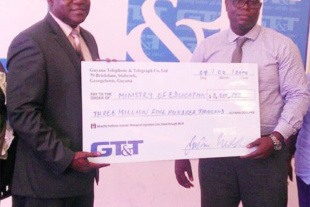 Chief Education Officer Olato Sam (left) receiving a cheque from GT&T Chief Financial Officer Justin Nedd for the Children’s Costume Parade 2014.
