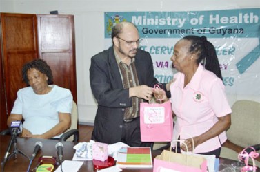 Health Minister Dr Bheri Ramsaran (centre) presents a token to a member of the Periwinkle Club (GINA photo) 