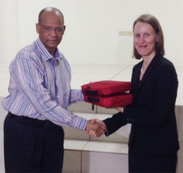 Minister of Home Affairs Clement Rohee (left) receives two of the 200 fraudulent document detection kits from Canadian High Commissioner Nicole Giles (right).  