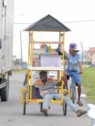 This young man was captured taking a shady ride on his friend’s food cart along the West Coast Demerara road at Uitvlugt. (Photo by Arian Browne)