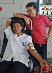 Marian Academy Principal Sister Marie Harper looks on proudly while a student makes his donation. (Photo by Rebecca Low)