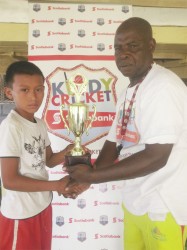 Ming Wong, skipper of the Kuru Kururu team receives the trophy from Guyana Cricket Board coordinator Andrew Alleyne. 