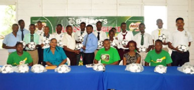 Beepat’s Treion D’Anjou presents a game ball to a student of St. George’s High School, the defending champions during yesterday’s briefing with coaches and captains of the Milo U-20 school tournament. (Orlando Charles photo)
