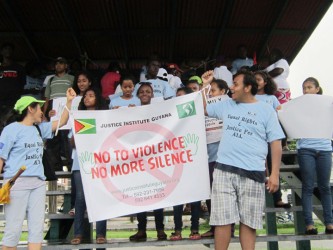 Participants in the Justice Institute Guyana ‘Walk for Equality’ hoist their banner, at the closing held at Parade Ground on Sunday.  