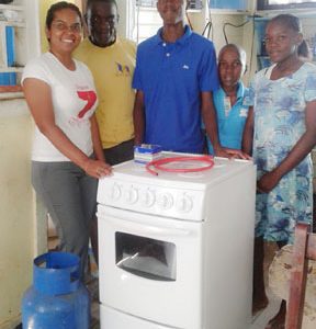 Vidya B. Sanichara - Digicel Communica-tions Manager (at left) donates the gas stove to the Dundas family