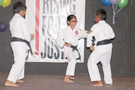 A young student of the Guyana Karate College goes on the offence against her classmates during a self-defence demonstration at yesterday’s One Billion Rising event. (Arian Browne photo)