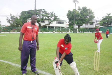 Coach Quacen Nedd teaching Sanyu Williams of Queen’s College the forward defence.
