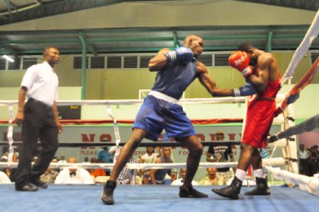 Best male boxer of the Goodwill Boxing Tournament, Dennis Thomas, (blue) on the attack against Jamaican, Michael Gardner in the bout of the tournament. 
