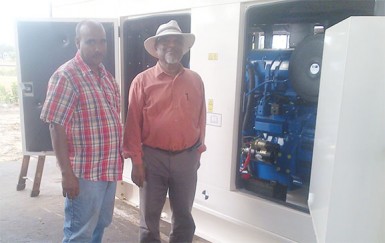 Prime Minister Samuel Hinds and Chairman of LMPCI John Macedo standing in front of one of the new generators which arrived in Lethem on Friday. 