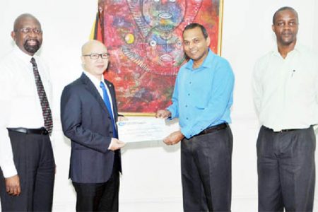 CHEC CJIA Project Manager Kevin Liu (second from left) hands over the cheque to Culture Minister Dr Frank Anthony. Also in photo from right are Permanent Secretary in the Ministry of Culture, Alfred King and Alex Graham of Tagman Inc. (CHEC photo)