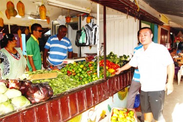 Zorina (left) and ‘Sugar’  (third from left) with customers at the couple’s Bourda Green vegetable outlet