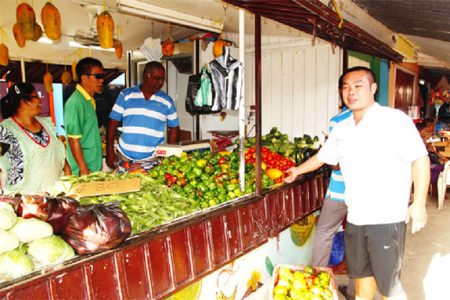 Zorina (left) and ‘Sugar’  (third from left) with customers at the couple’s Bourda Green vegetable outlet