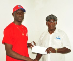 Organiser of the event, Randolph Roberts (right) receiving the sponsorship cheque from CEO of the Benjamin’s Sports Store, Wilbert Benjamin.