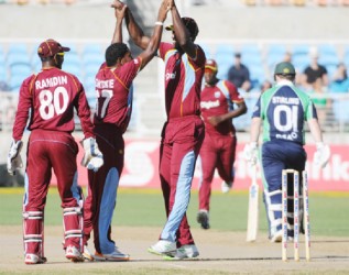 Krishmar Santokie and his teammates celebrate the fall of Paul Stirling’s wicket. (WICB media photo)  