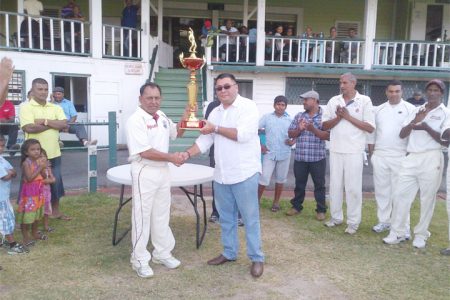 Raj Singh hands over the trophy to captain of the winning team Sheik Mohamed.