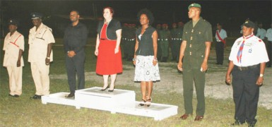 Gail Teixeira (centre), flanked by Regional Chairman Sharma Solomon and MP Vanessa Kissoon and officers of the police, military and scouts during the hoisting of the flag in Linden 