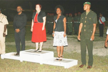 Gail Teixeira (centre), flanked by Regional Chairman Sharma Solomon and MP Vanessa Kissoon and officers of the police, military and scouts during the hoisting of the flag in Linden
